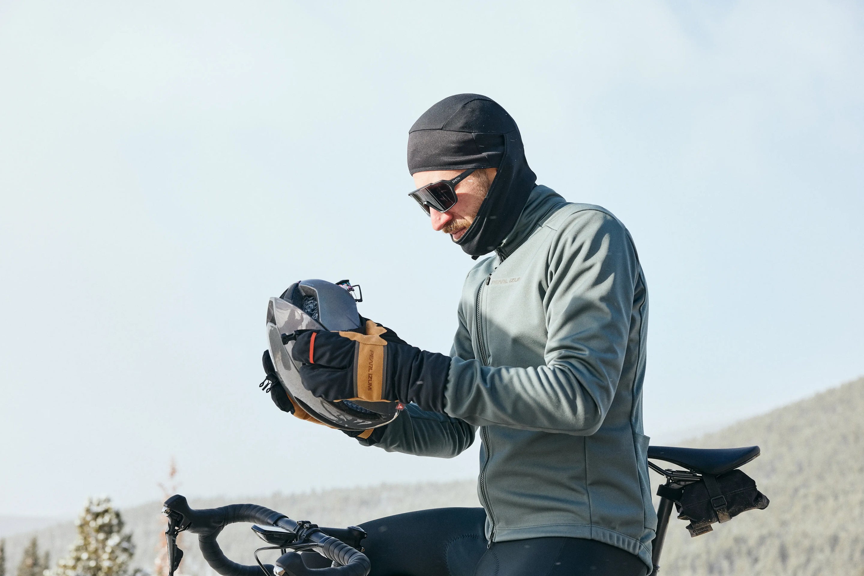Male cyclist preparing to go ride in the cold while wearing PEARL iZUMi Lobster Gloves